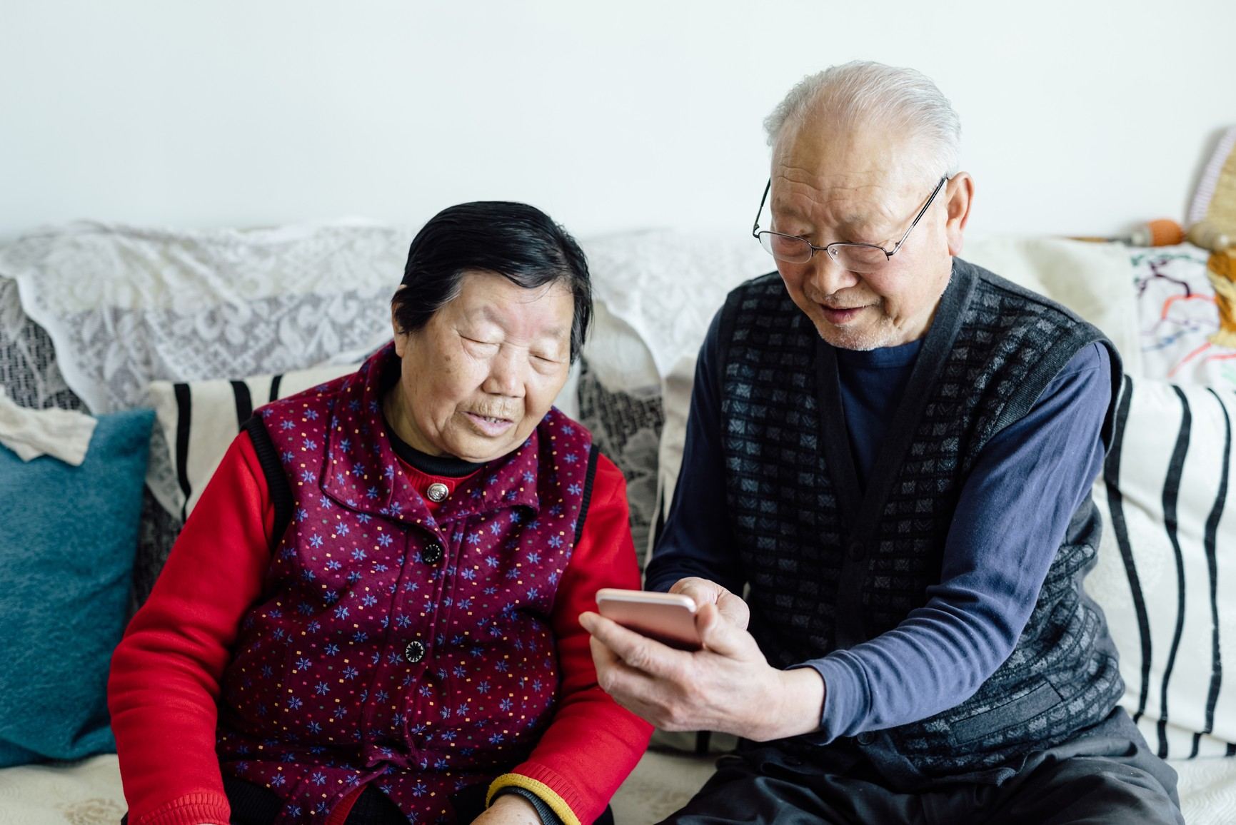 An older couple looking at a phone together